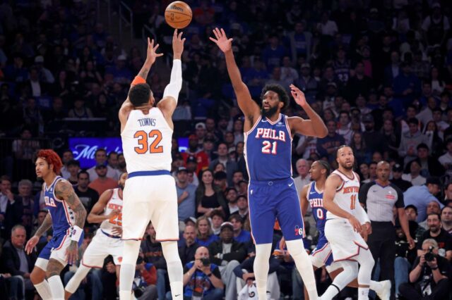 O pivô do New York Knicks, Karl-Anthony Towns # 32, lança um chute sobre o pivô do Philadelphia 76ers, Joel Embiid # 21, no primeiro quarto de um jogo dos playoffs da NBA.