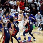 O pivô do New York Knicks, Karl-Anthony Towns (32), procura o homem aberto enquanto o atacante do Cleveland Cavaliers, Dean Wade (32), defende durante o segundo quarto.