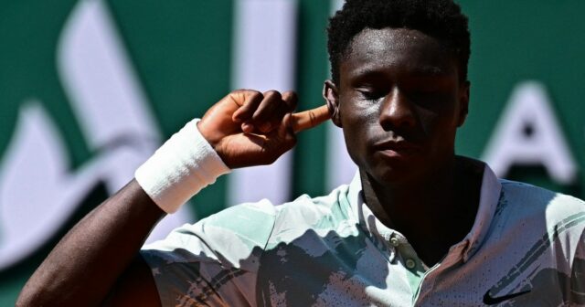 O francês Moise Kouame comemora sua vitória sobre o croata Marin Cilic durante a partida individual masculina no terceiro dia do torneio de tênis do Aberto da França na quadra Simonne-Mathieu em Roland-Garros 