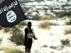 Líder terrorista do ISIS em liberdade após ataque dos EUA matar comandante em meio à crescente ameaça à África: analista Combatente mascarado do Estado Islâmico segura bandeira do ISIS no deserto