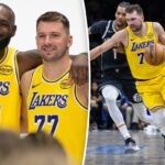 Jogador do Los Angeles Lakers com camisa amarela driblando um jogador do Brooklyn Nets com camisa preta.