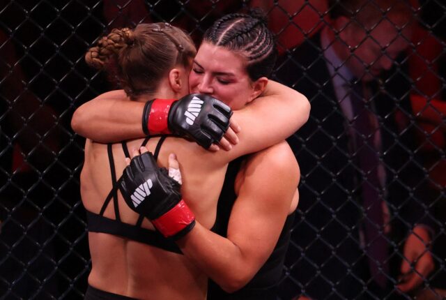 Luta Ronda Rousey x Gina Carano: Rousey vence com finalização INGLEWOOD, CALIFÓRNIA - 16 DE MAIO: Gina Carano e Ronda Rousey ficam com o árbitro John McCarthy após sua luta de peso pena durante o card principal de Ronda Rousey da Netflix x Gina Carano no Intuit Dome em 16 de maio de 2026 em Inglewood, Califórnia. Sarah Stier/Getty Images para Netflix/AFP (Foto de Sarah Stier/GETTY IMAGES NORTH AMERICA/Getty Images via AFP)