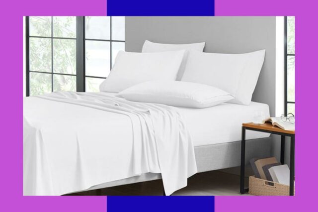 Luxo silencioso aprovado: economize 75% nessas folhas de bambu luxuosas Lençóis brancos numa cama ao lado de uma mesa de cabeceira com um livro e óculos.