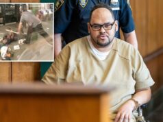 Madman descobre seu destino por espancar brutalmente uma mulher deficiente na estação de metrô de Nova York Um homem de macacão laranja, óculos e quipá, está sentado em uma cadeira de rodas, algemado, com um policial parado atrás dele.