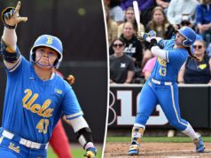 Megan Grant, rebatedora da UCLA, quebra o recorde de home run em uma única temporada da NCAA Uma jogadora de softball da UCLA com uniforme azul e capacete levantando a mão enluvada no ar.