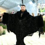 Parecendo uma caneta de pena! O artista Sam Smith usou uma roupa preta deslumbrante que apresentava uma capa dramática e overzied forrada com pele e uma bainha estilo sereia que abraçava a parte inferior. Eles combinaram o visual com um grande capacete combinando que incluía duas penas pretas extremamente altas