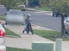 Momento insano motorista persegue criança pela calçada de bairro suburbano com seu carro: ‘Essa mulher é louca!’ Um menino de capacete andando de bicicleta suja na calçada.