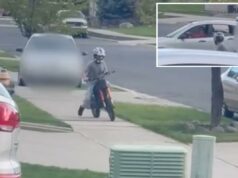Motorista filmada perseguindo criança na calçada é uma veterinária do Exército que estava tão bêbada que ‘plantou o rosto’ na casa do vizinho: relatório Um jovem em uma bicicleta suja vermelha com um capacete branco dirige em uma calçada, com um carro cinza embaçado atrás dele.