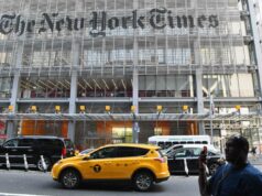 New York Times processado por discriminação depois que homem branco foi preterido para promoção: processo da EEOC Um homem segura um smartphone em frente ao prédio do New York Times.