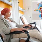 Uma mulher com lenço na cabeça recebendo quimioterapia por infusão em ambiente hospitalar.