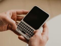 O Clicks Communicator está recebendo um grande aumento de bateria e Android 17 pronto para uso Uma mão segurando o Comunicador Clicks, flanqueado por vistas angulares destacadas.