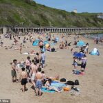 As pessoas aproveitaram o clima quente na praia de Sunny Sands em Folkestone, Kent, na tarde de sexta-feira