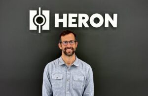 O ex-executivo da Tesla e CEO da Heron Power, Drew Baglino, fundou uma startup de bombas de calor Drew Baglino standing in front of the Heron Power logo.