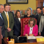O governador de Iowa, Kim Reynolds, assina o Arquivo 2289 do Senado, expandindo a fiscalização do jogo e atualizando as regras de retenção de impostos em Des Moines.