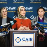 Hiba Rahim, Diretora Executiva do CAIR Flórida, falando em uma entrevista coletiva com outras duas pessoas ao lado dela.