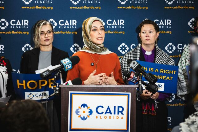 Hiba Rahim, Diretora Executiva do CAIR Flórida, falando em uma entrevista coletiva com outras duas pessoas ao lado dela.