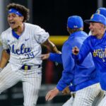 Um exultante Mulivai Levu (à direita) será assediado por companheiros de equipe depois de acertar a mosca de sacrifício da vitória no nono turno da vitória da UCLA por 4-3 sobre Purdue nas quartas de final do Big Ten em 22 de maio de 2026 em Omaha, Nebraska.