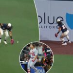 Um jogador de beisebol com uniforme branco e azul escuro e uma luva vermelha joga uma bola de beisebol em um campo verde durante um jogo com um placar mostrando Cardinals vs. Padres, 5ª entrada, placar de 0-0.