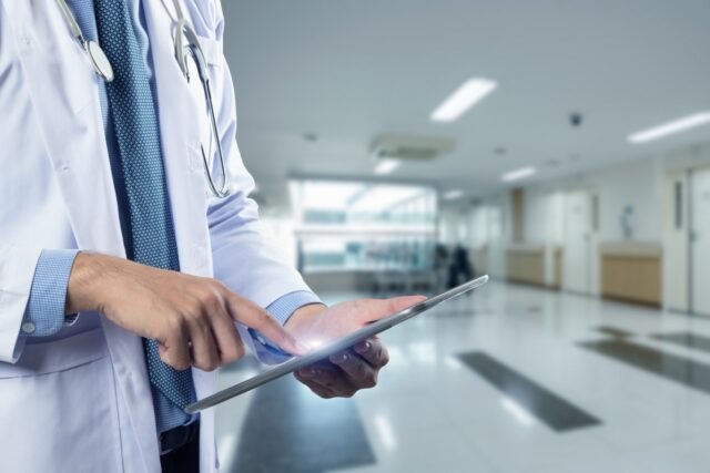 O novo modelo de pagamento do Medicare foi desenvolvido para Close-up of a physician's hands holding a tablet, used in a post about healthcare startup Regard