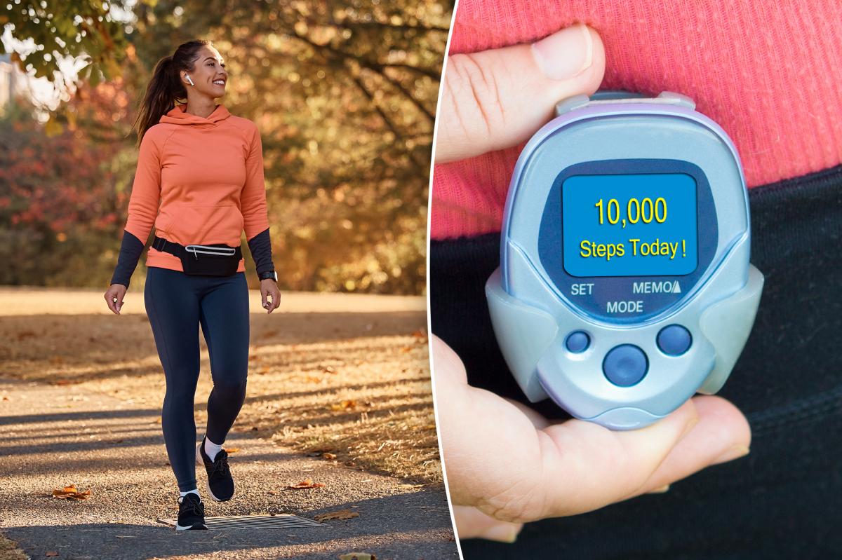 Uma mulher atlética feliz com fones de ouvido, um moletom com capuz laranja e leggings escuras caminha por um parque de outono.