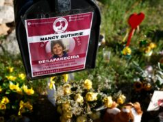 O pai de JonBenét Ramsey diz que a família de Nancy Guthrie deveria examinar a polícia Flowers and signs are seen in a makeshift memorial in front of the home of Nancy Guthrie on February 27, 2026 in Tucson, Arizona.