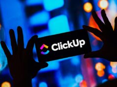 O que a demissão em massa da ClickUp nos diz sobre o futuro do trabalho ClickUp logo on a smartphone