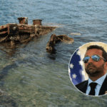 U.S. sailors stand amid wreckage watching as the