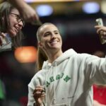 Sabrina Ionescu, que estrelou pelo Oregon Ducks, tira uma selfie com um fã antes da derrota do Liberty por 98-96 para o Fire em 12 de maio de 2026 em Portland, Oregon.