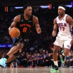 O jogador do New York Knicks, Og ​​Anunoby, dirige até a cesta enquanto é defendido pelo jogador do Philadelphia 76ers, Vj Edgecombe.