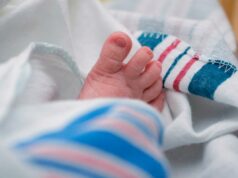 Olivia e Liam estão no topo da lista dos nomes de bebês mais populares dos EUA pelo sétimo ano consecutivo Um close dos dedinhos dos pés de um bebê enrolados em um cobertor listrado de branco e azul.