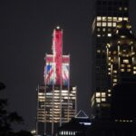 Edifício iluminado com a bandeira Union Jack à noite.