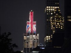 Os britânicos estão chegando – e desta vez eles falam sério Edifício iluminado com a bandeira Union Jack à noite.