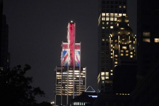 Os britânicos estão chegando – e desta vez eles falam Edifício iluminado com a bandeira Union Jack à noite.