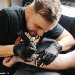Os ministros comprometeram-se a reprimir um esquema que concede aos requerentes benefícios laptops financiados pelos contribuintes e até equipamento de tatuagem quando estes conseguem novos empregos. Na foto: Um tatuador trabalhando (imagem de arquivo)