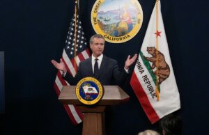 Os mitos e números de Gavin Newsom orçam apenas um anúncio de campanha para 2028 O governador Gavin Newsom fala em um pódio próximo a uma tela que exibe estatísticas econômicas dos EUA e imagens de Joe Biden e Donald Trump.