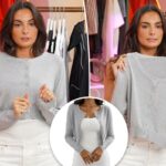 Uma mulher vestindo um cardigã cinza de botões sobre um vestido branco.