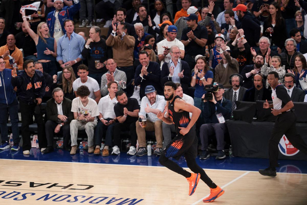 O guarda do New York Knicks, Jalen Brunson # 11, comemorando um arremesso de 3 pontos contra o Cleveland Cavaliers, com fãs torcendo ao fundo.