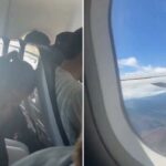 Um passageiro de avião vomitando em um saco.