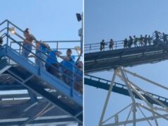 Passageiros do Six Flags presos a 245 pés no ar depois que uma queda de energia força a evacuação da montanha-russa Pessoas evacuando uma montanha-russa por uma escada de metal azul após uma queda de energia.