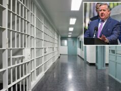 Pena de prisão obrigatória por fraude contra contribuintes? Absolutamente Um corredor de prisão vazio com grades brancas na parede esquerda e portas e molduras verde-azuladas à direita.