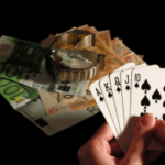Pessoa segurando a mão de pôquer royal flush ao lado de notas de euro e relógio de luxo simbolizando ganhos em jogos de azar, apostas em cassinos e risco financeiro. Pesquisadores universitários lançam um grande centro independente de evidências de danos ao jogo no Reino Unido