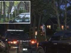 Policiais de Long Island matam a tiros filho acusado de esfaquear mãe deficiente no Dia das Mães Um carro da polícia estacionado em frente a uma casa com fita amarela de cena do crime no gramado.