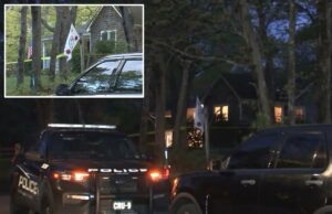 Policiais de Long Island matam a tiros filho acusado de esfaquear mãe deficiente no Dia das Mães Um carro da polícia estacionado em frente a uma casa com fita amarela de cena do crime no gramado.