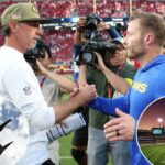 Dois treinadores de futebol do Los Angeles Rams e do San Francisco 49ers apertam as mãos em campo.