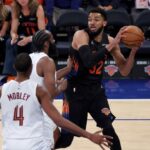 O pivô do New York Knicks, Karl-Anthony Towns, vai para a cesta enquanto o guarda do Cleveland Cavaliers, Donovan Mitchell, defende durante o jogo 1 das finais da Conferência Leste.