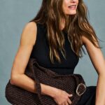Yasmin usando vestido midi preto texturizado (£ 20) e bolsa hobo de palha marrom chocolate (£ 22)
