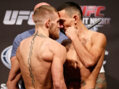 Probabilidades do UFC 329: Max Holloway abre como favorito na luta de volta de Conor McGregor Conor McGregor falando em entrevista coletiva de boxe com um cinturão de campeão e produtos em uma mesa à sua frente.