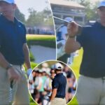 Rory McIlroy olha para o campo de golfe, com uma tabela de classificação mostrando-o em quinto lugar.