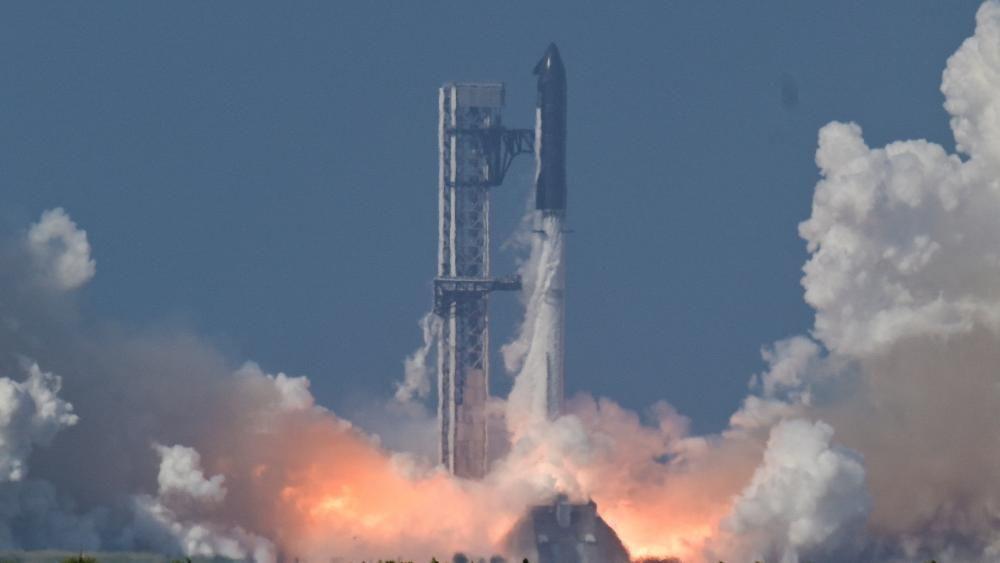 Um foguete espacial voa para cima em um céu azul claro, deixando um enorme rastro cinza atrás de si em uma faixa cada vez maior.