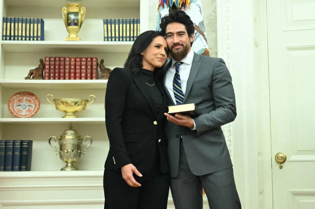 Tulsi Gabbard renuncia ao cargo de chefe da inteligência, citando Tulsi Gabbard e seu marido Abraham Williams se abraçam antes de ela tomar posse como diretora de inteligência nacional no Salão Oval em 12 de fevereiro de 2025. / Crédito: ANDREW CABALLERO-REYNOLDS/AFP via Getty Images